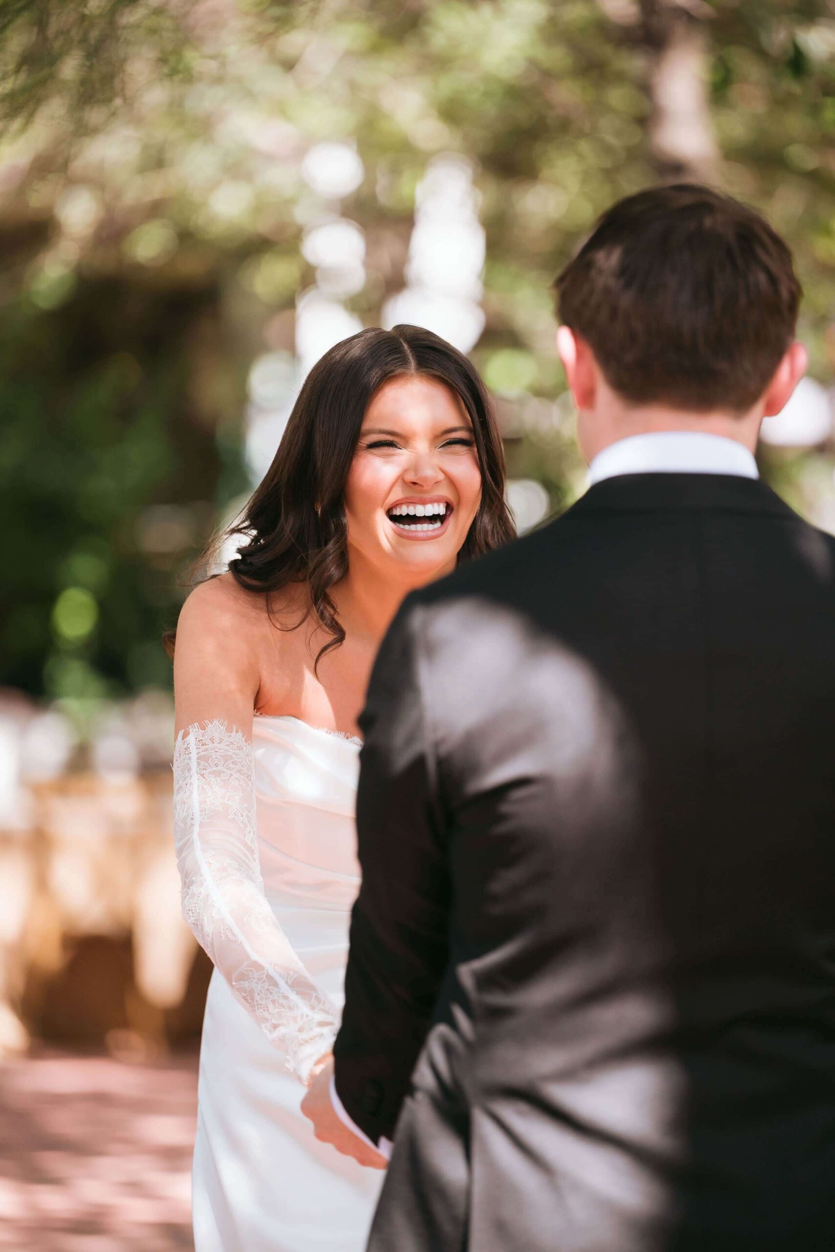 Bride laughing with groom during a candid outdoor wedding moment