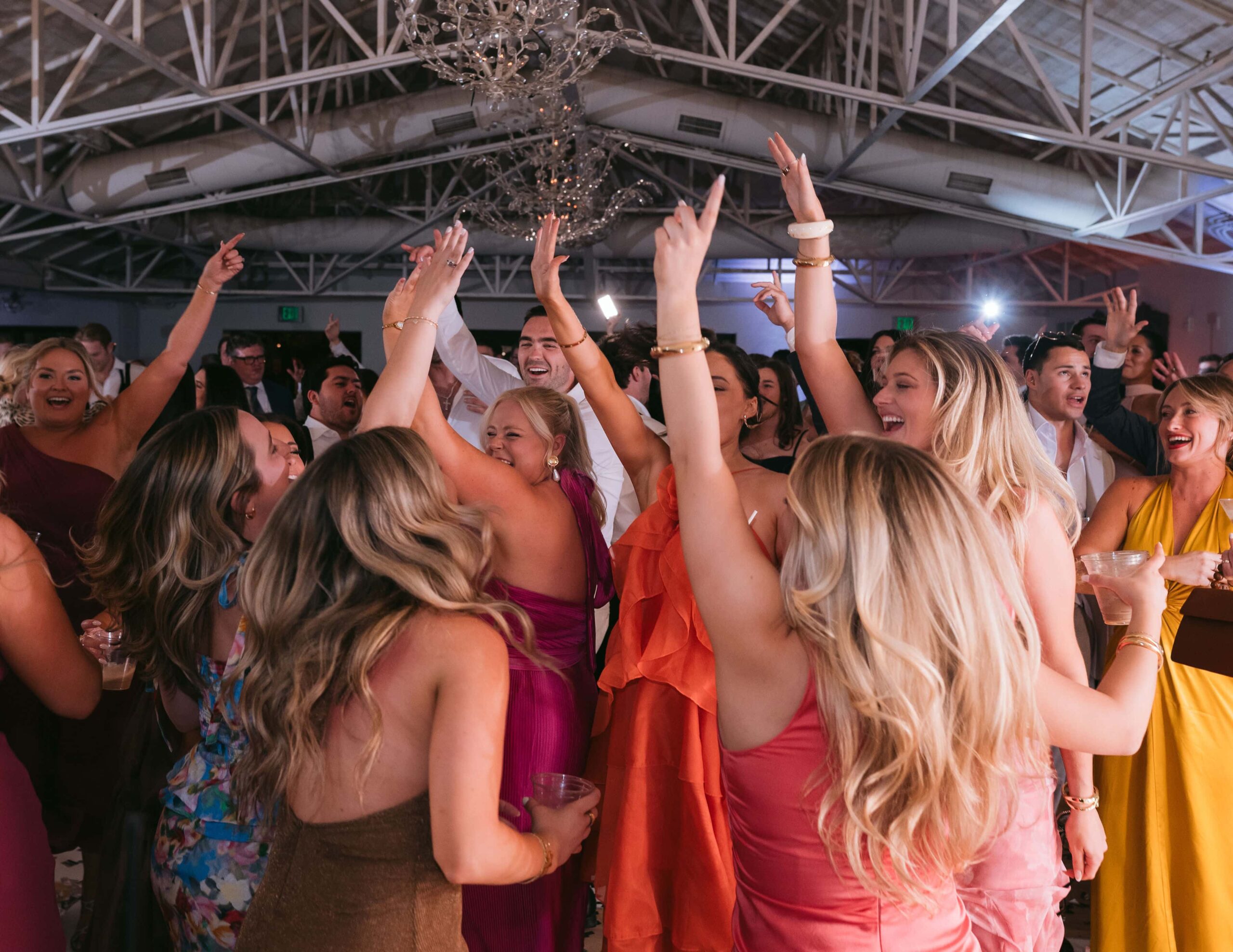 Wedding guests dancing together at a reception, capturing the candid energy of the celebration